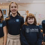 Marketing strategies for school enrollment. Four students in a class room smiling for a photo.